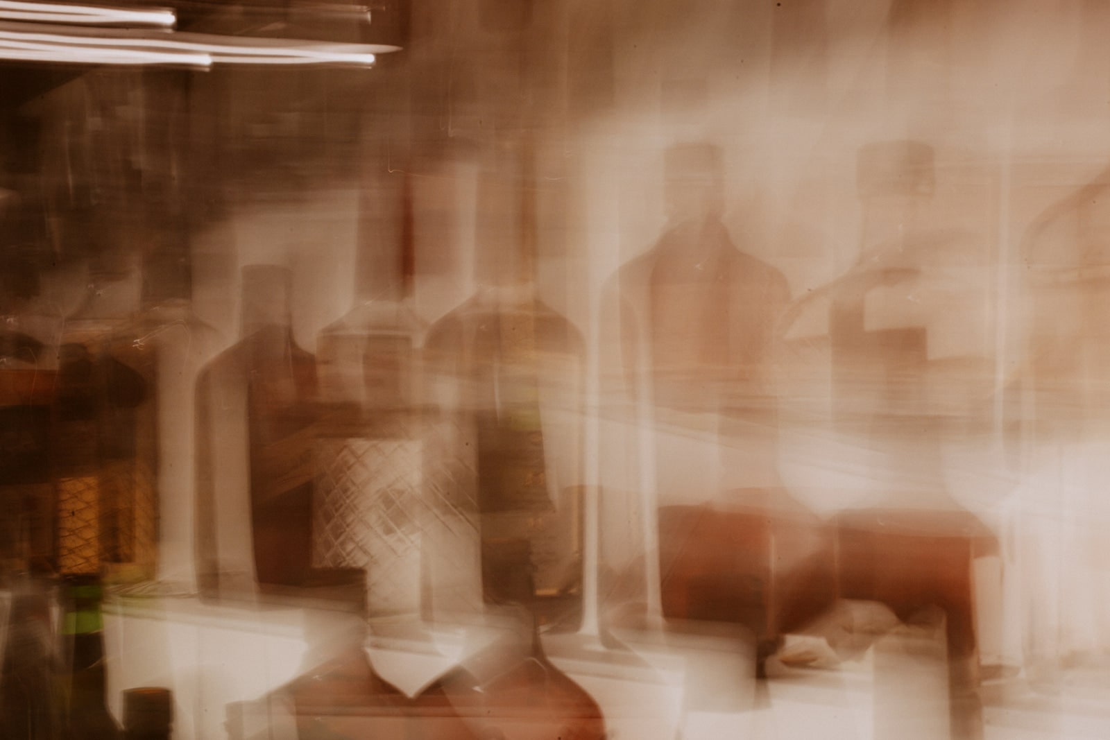 Rows of glass perfume bottles in warm light
